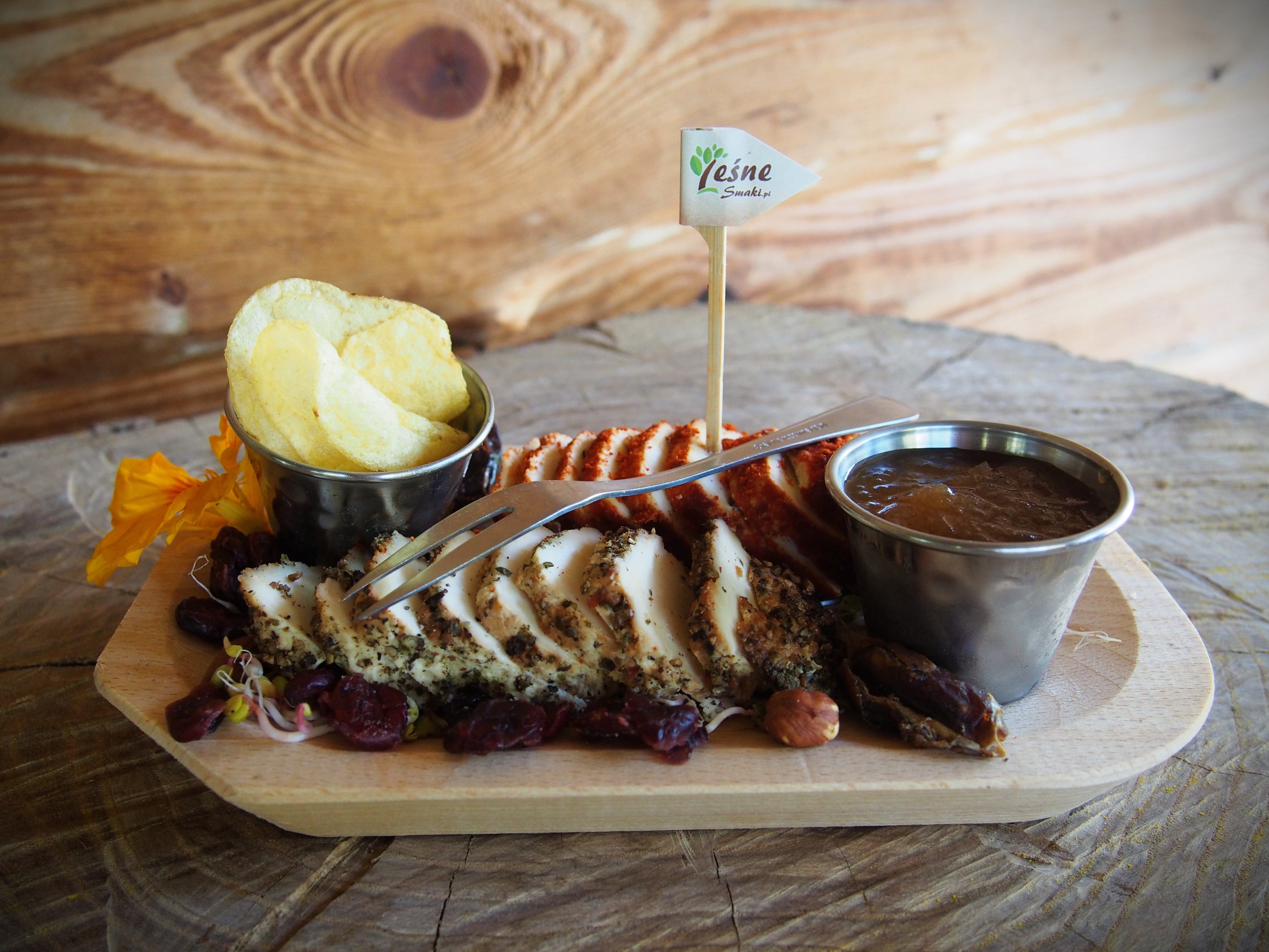 Kawałki pokrojonego mięsa podane na drewnianej desce.